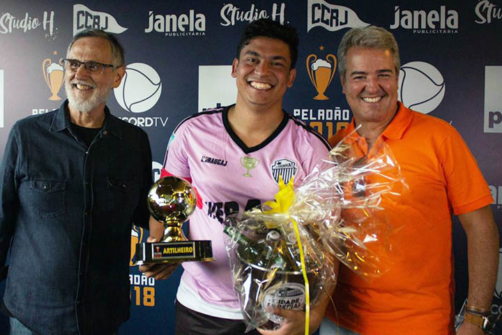 O artilheiro do Peladão 2018, Davi Souza, recebe seu troféu das mãos de Thomaz Naves (à direita na foto), diretor da Record TV Rio, patrocinadora do evento.