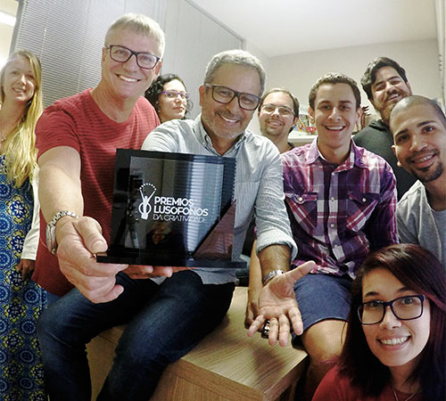 A equipe da Enzimas em Ação, com seu diretor Beto Galindo à frente -- comemora o troféu do Prêmio Lusófonos.