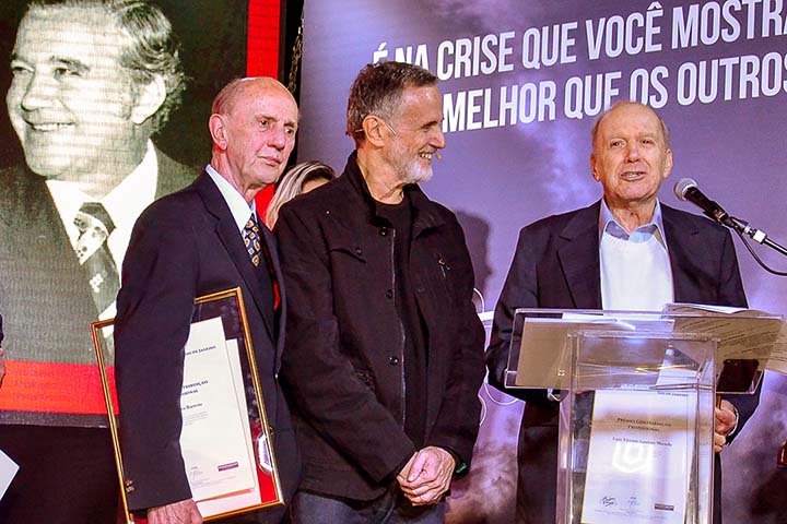 Em 09/06/2016, Marcio Ehrlich entrega o Prêmio Contribuição Profissional a Evandro Barreto e Luiz Macedo